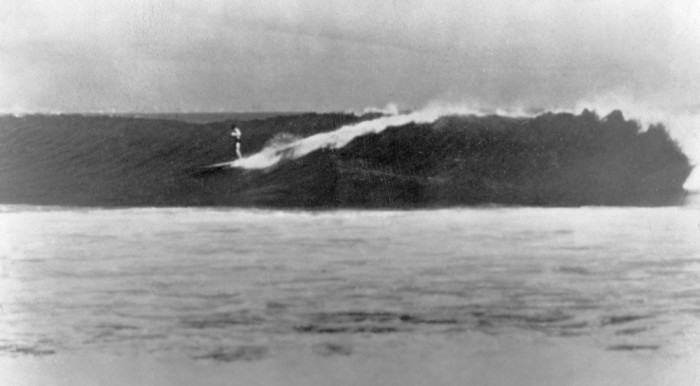 This is a rare photo supposedly taken by Bob Prosser, unknown and long gone, thought to be a Hollywood porn photographer who just came along that day. It is the biggest wave ever photographed with any rider getting in so early demonstrating great speed not before seen. It is unusual to see Simmons with his feet together and looking down and evaluating his trim balance. Not unusual for Simmons. He later gave Simmons copies of this photo which Simmons was very proud of. He gave personally gave me this copy as his friend. The ride and size of the wave has not been replicated to this day. Note: not another surfer can be seen, nor could they surf anything like this on the old planks and paddle boards. This is a rare photo supposedly taken by Bob Prosser, unknown and long gone, thought to be a Hollywood porn photographer who just came along that day. It is the biggest wave ever photographed with any rider getting in so early demonstrating great speed not before seen. It is unusual to see Simmons with his feet together and looking down and evaluating his trim balance. Not unusual for Simmons. He later gave Simmons copies of this photo which Simmons was very proud of. He gave personally gave me this copy as his friend. The ride and size of the wave has not been replicated to this day. Note: not another surfer can be seen, nor could they surf anything like this on the old planks and paddle boards.
